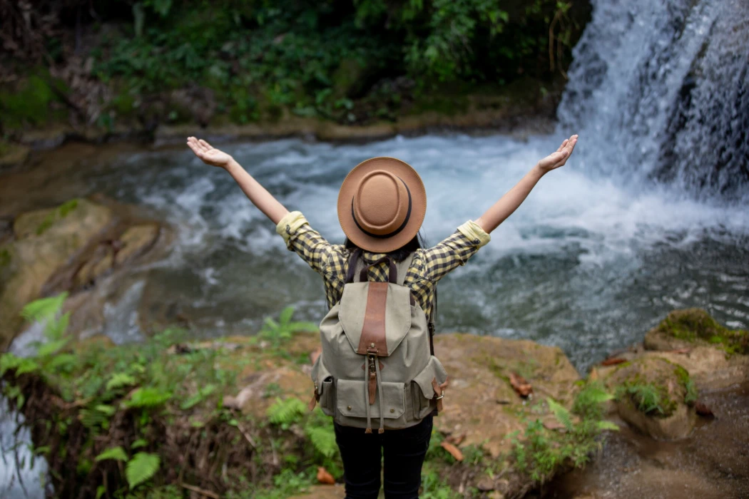 Female tourists are happy and refreshed at the waterfall.